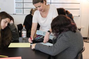 Math teacher Ann Sharp helping student Isabella Armstrong.