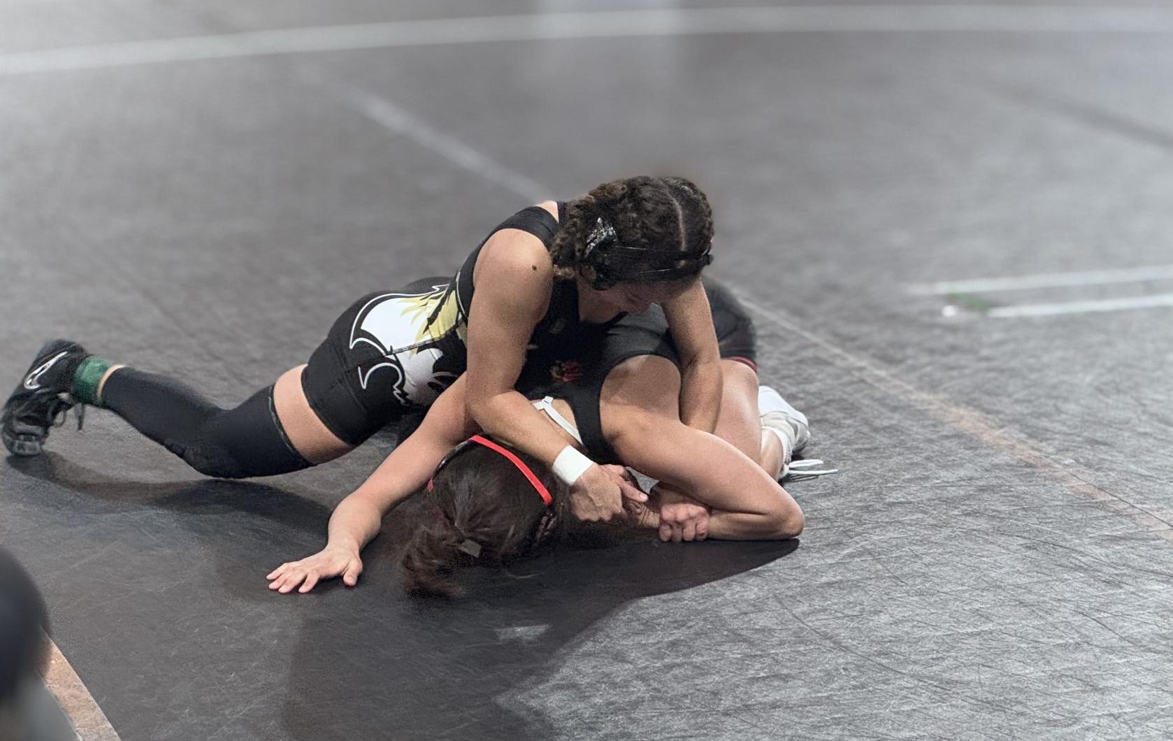 Alexa Braton wrestling at the DonnyBrook meet in Iowa. “I was very stressed but I knew that once I got on top that I would win.” Junior Alexa Braton said. Photo by Kerri Winzer. 

