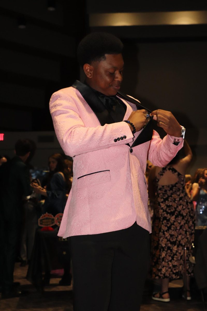 Dress To Impress. Junior Treston Long pulls out his prom ticket. “I was really dripped out with the pink, and I was rocking out everything.” Long said.