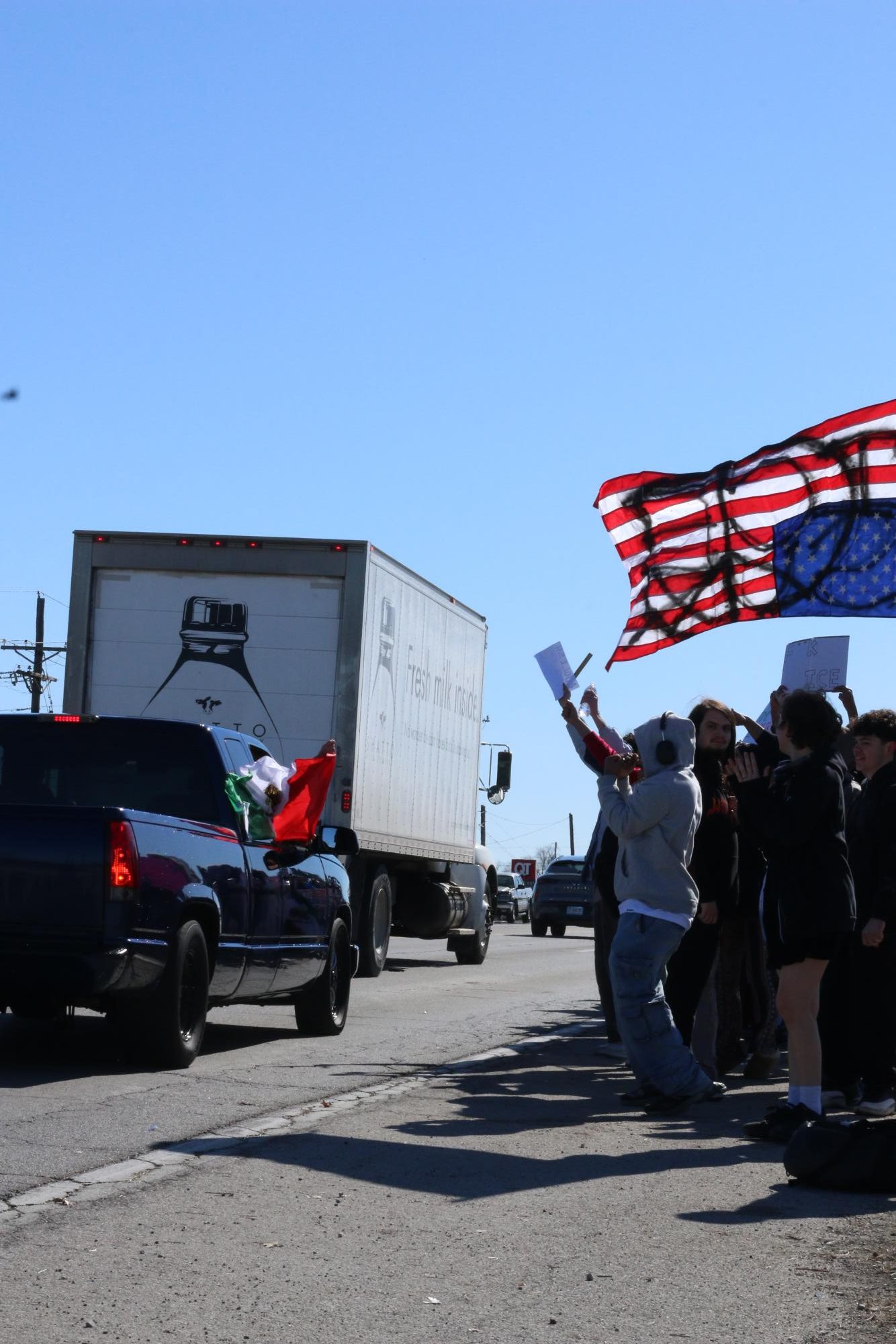 Cars drive by the protest on 291 Highway.

