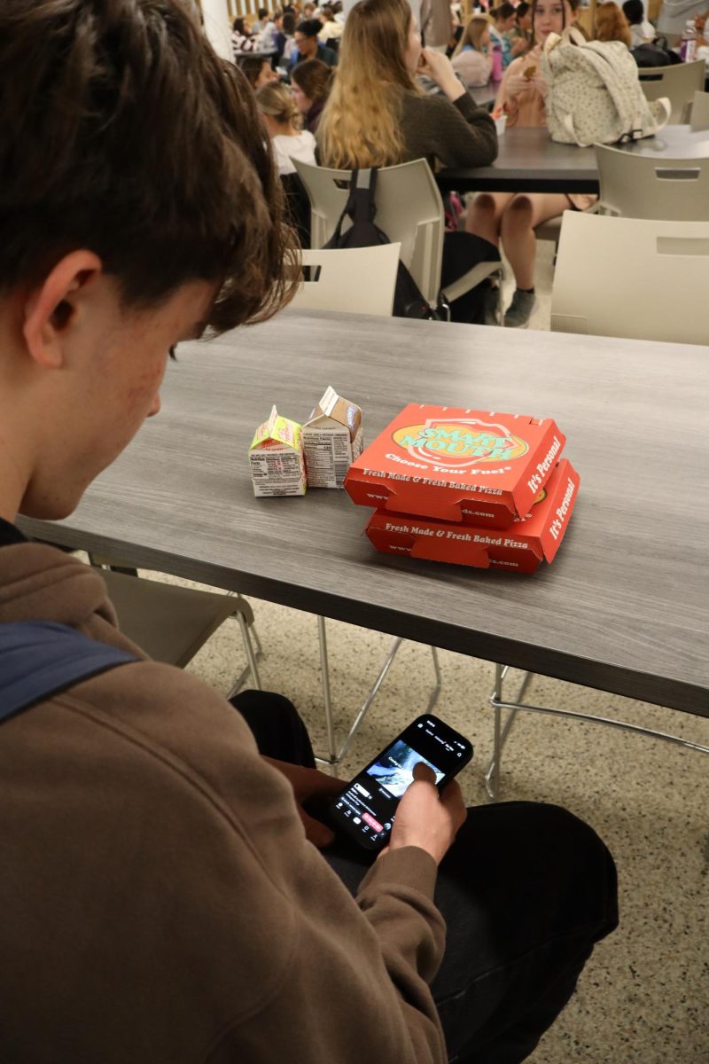 Student hides cell phone under lunch table.Missouri passed a law recently prohibiting phones at school. 